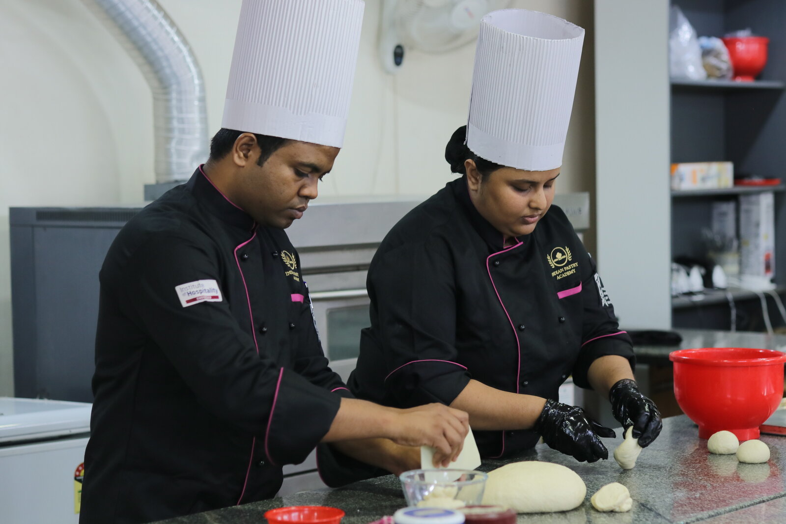 Indian Pastry Academy chef instructor and student shaping dough at the training bench